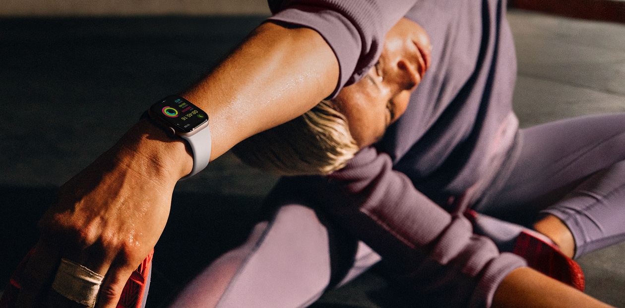 En kvinna som stretchar med en Apple Watch på handleden.
